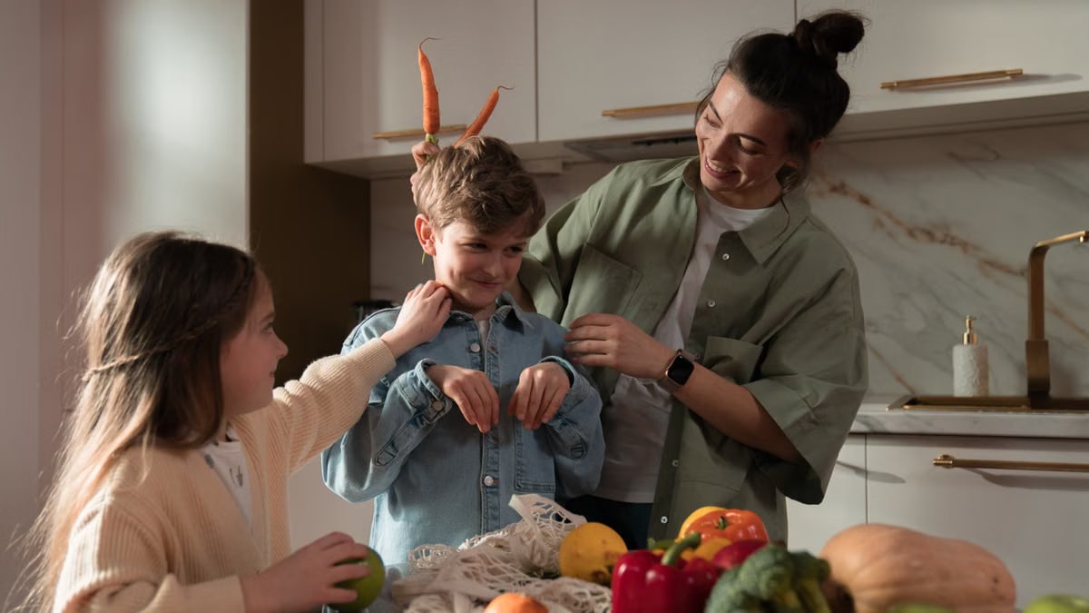 Mother and children have fun unpacking vegetables in the kitchen.